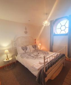 a bedroom with a bed with a window and a chandelier at Seaside Summer Room in Ramsgate