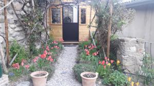 una puerta de entrada de una casa pequeña con flores en Maison aux Lavandes The Studio, en Vaumeilh