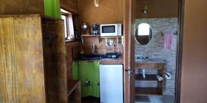 a small kitchen with a white refrigerator and a sink at Chalés Portal Verde - Seja bem vindo in Carrancas