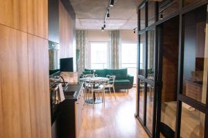 sala de estar con mesa y sofá verde en Topaz Apartamenty en Augustów