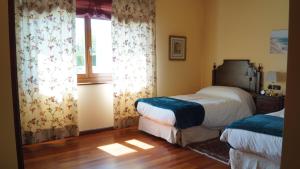 una camera con due letti e una finestra di Hotel Batán a Villalba