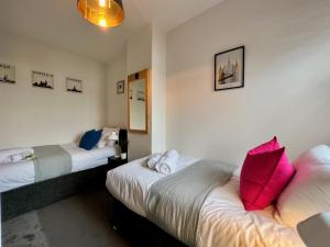 ein Hotelzimmer mit zwei Betten mit roten Kissen in der Unterkunft Johnson House - Great for Contractors or Family Holidays in Cleethorpes + 25 Fotos