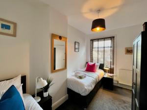a bedroom with two beds with pink pillows at Johnson House - Great for Contractors or Family Holidays in Cleethorpes