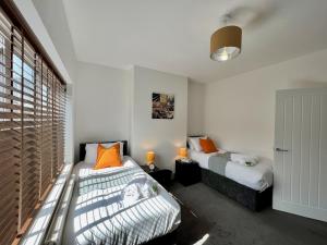 a bedroom with two beds and a window at Johnson House - Charm Townhouse in Cleethorpes
