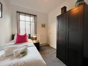 a bedroom with a bed with a pink pillow on it at Johnson House - Great for Contractors or Family Holidays in Cleethorpes