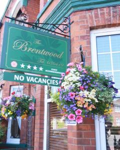 un cartello verde su un edificio con fiori di Brentwood Guest House a York