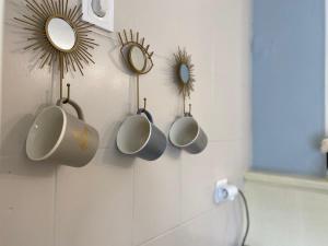 baño con 3 tazas colgadas en la pared en Van Life chambre avec Vidéo projecteur en LʼArbresle