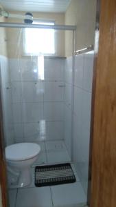 a bathroom with a toilet and a glass shower at Apartamento Caucaia-CE, próximo á praia de Cumbuco in Fortaleza