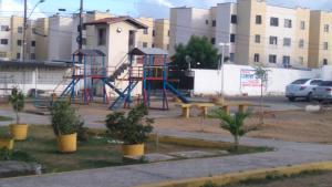 a playground in a parking lot next to a building at Apartamento Caucaia-CE, próximo á praia de Cumbuco in Fortaleza