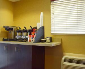 a kitchen with a counter with a window and a shelf at Red Roof Inn Buffalo - Niagara Airport in Williamsville