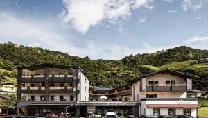 un edificio con una montagna sullo sfondo di Hotel Klostersepp - Neu a Chiusa