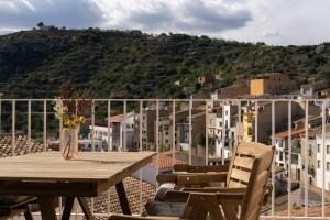 a table and chairs on a balcony with a view of a city at Ca Pelegrí in Useras
