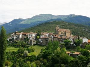 un pueblo en una colina con montañas en el fondo en APARTAMENTO CASA PALOMA, en Ansó