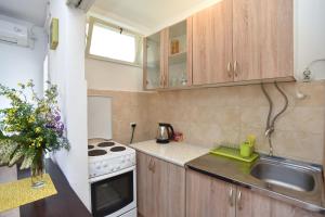 a small kitchen with a sink and a stove at Apartment near Old Town in Budva +5 photos