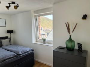 ein Schlafzimmer mit einem Bett und einer Vase auf einer Kommode in der Unterkunft Weingut Gästehaus Bach in Cochem