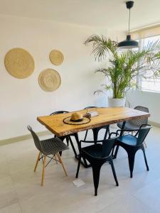 una mesa de madera y sillas en una habitación en TEYFA Hospedaje - Departamento, en Atuntaqui