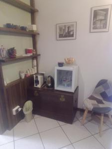 ein Wohnzimmer mit einem TV und einem Stuhl in der Unterkunft A CASA DI GEMMA in Bologna