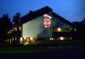a building with a neon sign on the side of it at Red Roof Inn Buffalo - Niagara Airport in Williamsville