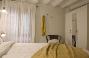 a bedroom with a bed and a chair and a window at Apartamento Tarazona Centro in Tarazona de Aragón