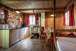 eine Küche mit Holzschränken und einem Tisch und Stühlen in der Unterkunft Wichtelhütte Silberregion Karwendel in Umlberg