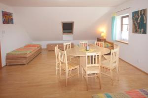a dining room with a table and chairs and a couch at Apartmán V sadu in Míšov