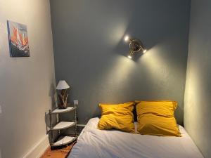 a bedroom with a bed with yellow pillows at Superbe appartement front de mer in Luc-sur-Mer