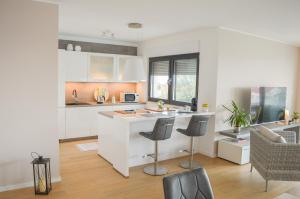 a kitchen with white cabinets and a counter top at Rova Apartment in Malinska
