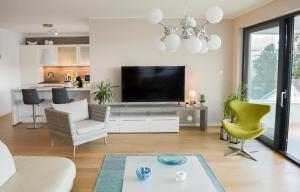 a living room with a television and a couch and chairs at Rova Apartment in Malinska