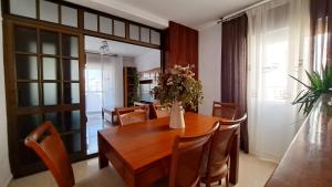 a dining room with a table with a vase of flowers on it at Victoria Home Córdoba in Córdoba