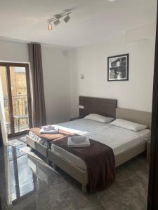 a bedroom with a bed and a large window at Sir William Strand in Il-Gżira