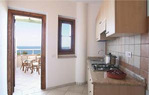 una cucina con vista su un balcone con tavolo di Cozy Apartment In Ricadi With Wifi a Ricadi