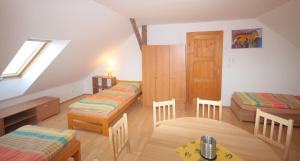 um quarto no sótão com 2 camas e uma mesa em Apartmán V sadu em Míšov