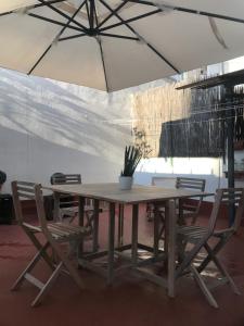 einem Holztisch mit Stühlen und einer Topfpflanze darauf in der Unterkunft 2 Apartamento TERRAZA Free Wifi in Valencia