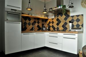 a kitchen with white cabinets and a counter top at Huis nummer 7 met sauna en 3 slaapkamers in Leeuwarden