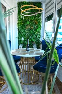 un comedor con 2 mesas y una pared verde en Luxury Apartment Karic FREE parking, en Tuzla