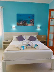 - une chambre avec un lit blanc et un mur bleu dans l'établissement Le Twins -Bed and Breakfast, à Tropea