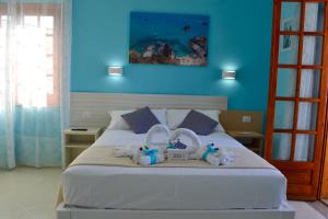 a bedroom with a bed with two stuffed animals on it at Le Twins -Bed and Breakfast in Tropea