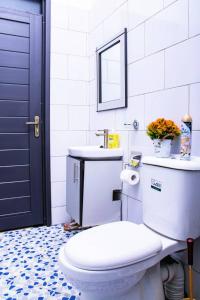 a bathroom with a white toilet and a sink at Sereneville 4 Deluxe Bukoto-Kisaasi Apartment in Kampala