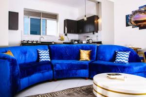 a blue couch in a living room with a table at Sereneville 4 Deluxe Bukoto-Kisaasi Apartment in Kampala