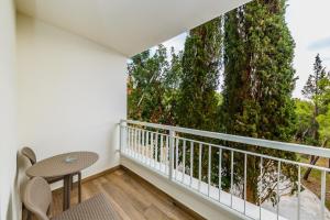 - un balcon avec une table et un arbre dans l'établissement Hotel Medena, à Trogir