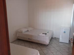 Habitación pequeña con cama y nevera pequeña. en Pousada Algaroba, en Bom Jesus da Lapa