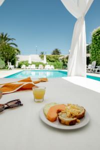 a plate of food on a table next to a pool at Atlántico Boutique Hotel in Punta del Este