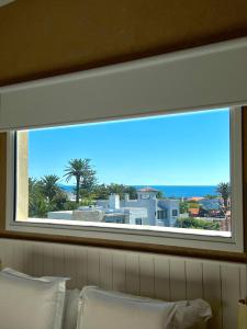 een raam boven een bed met uitzicht op de oceaan bij Atlántico Boutique Hotel in Punta del Este