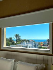a window over a bed with a view of the ocean at Atlántico Boutique Hotel in Punta del Este