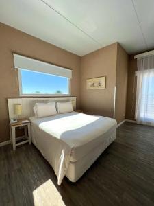 a bedroom with a large white bed with a window at Atlántico Boutique Hotel in Punta del Este