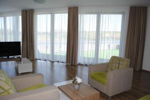 a living room with two chairs and a television at Hotel Golf Jezera in Ostrožská Nová Ves