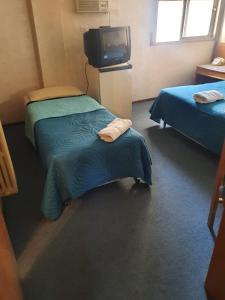 a hotel room with two beds and a tv at Apartamentos Plaza in Rosario