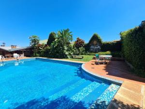 a swimming pool in front of a house at Hosteria Helvecia in Montecarlo