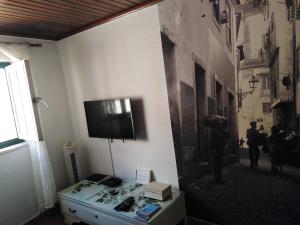 a room with a tv on a wall with a table at Alfama with a view in Lisbon