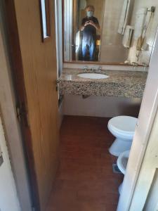 a man taking a picture of a bathroom with two toilets at Apartamentos Plaza in Rosario